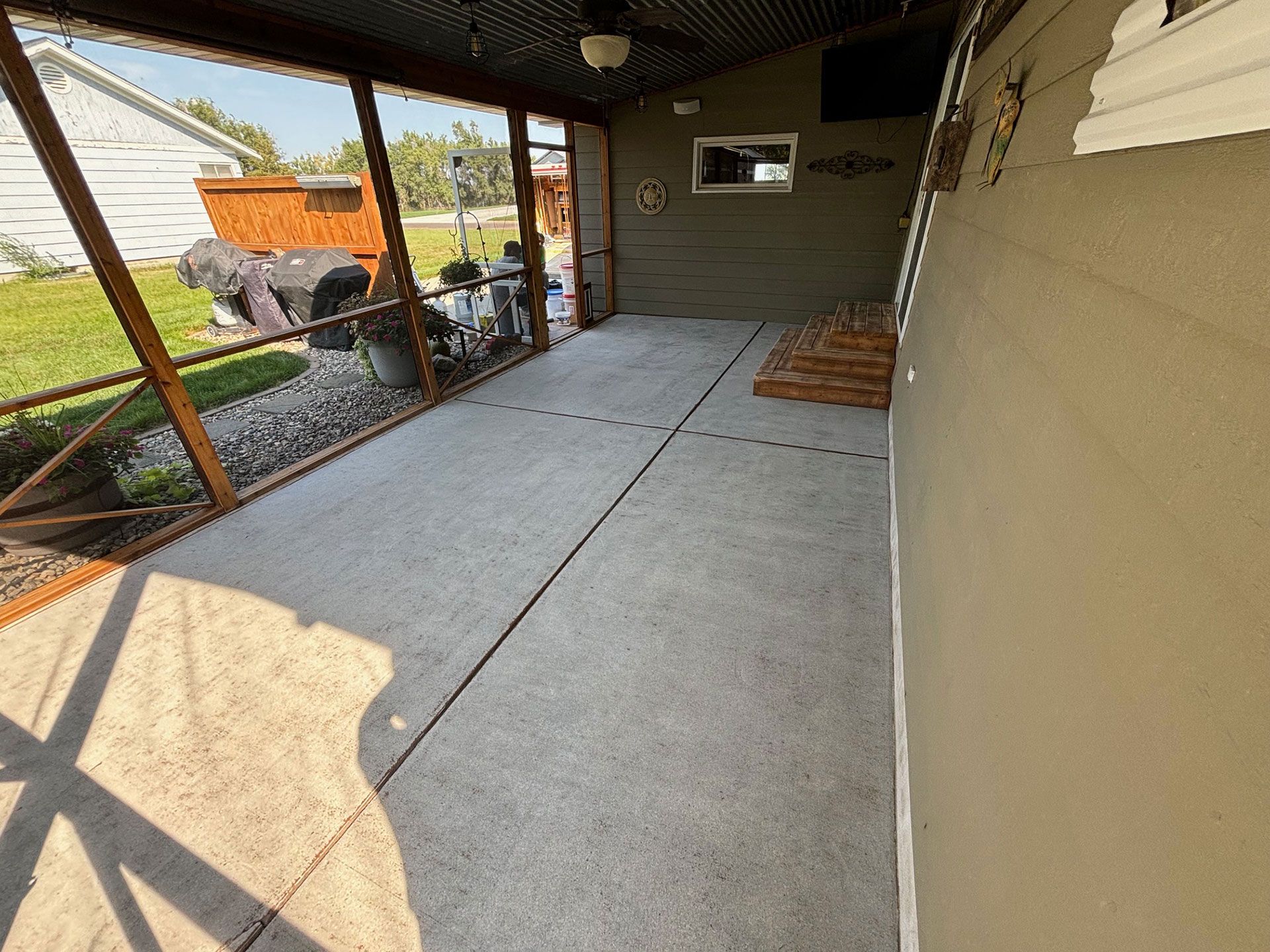 Before: A screened-in porch with a spacious concrete floor.