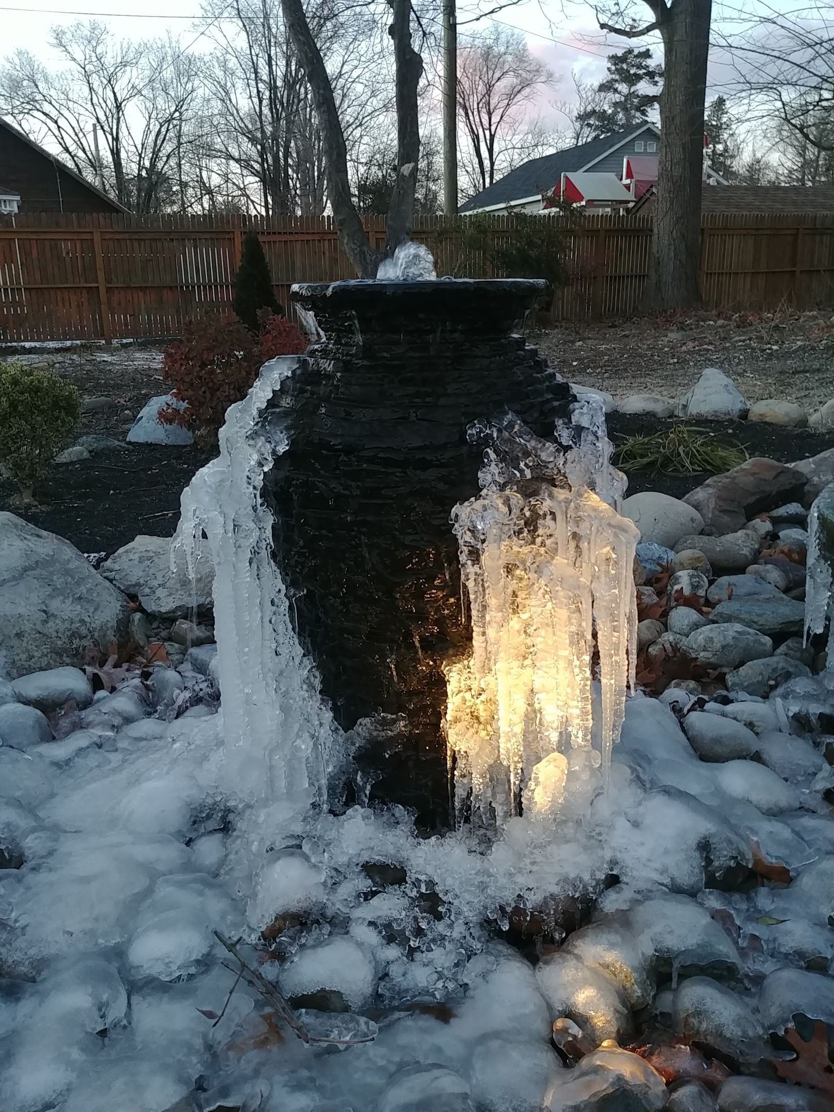 Frozen outdoor fountain with icicles and snow.
