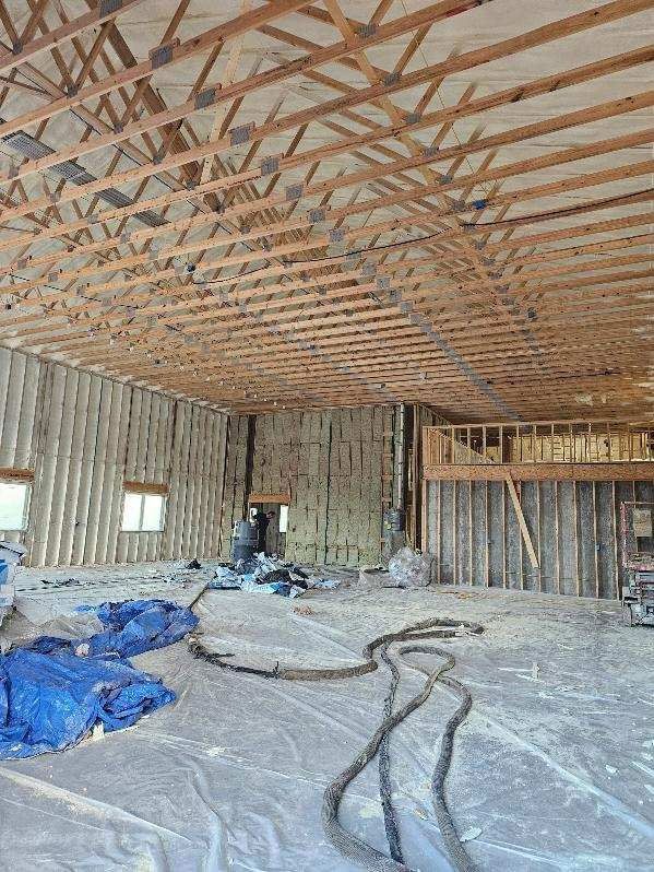 The inside of a building under construction with a lot of wooden beams