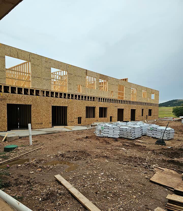 A large building is being built on a dirt field.