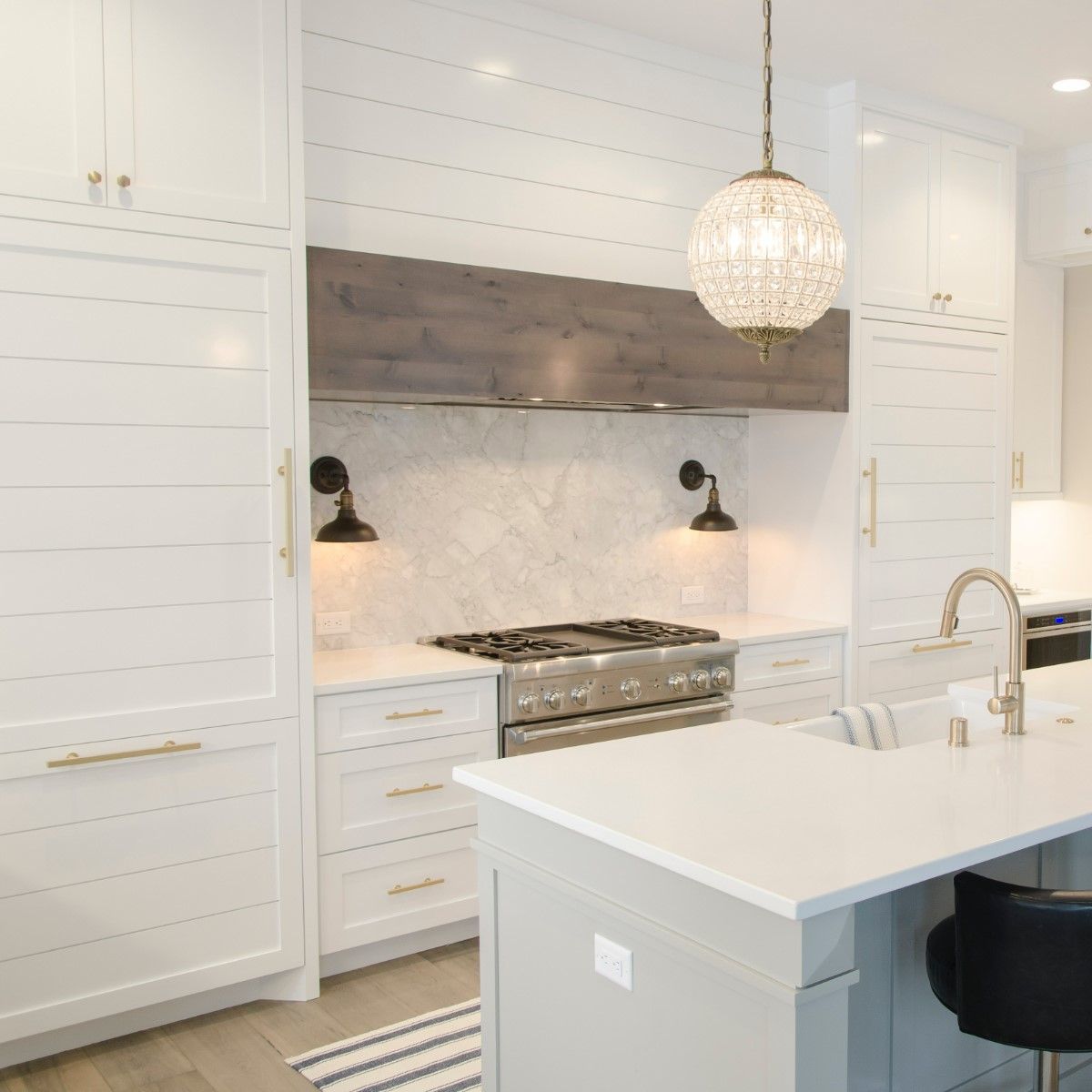 A kitchen with white cabinets , a stove and a sink.