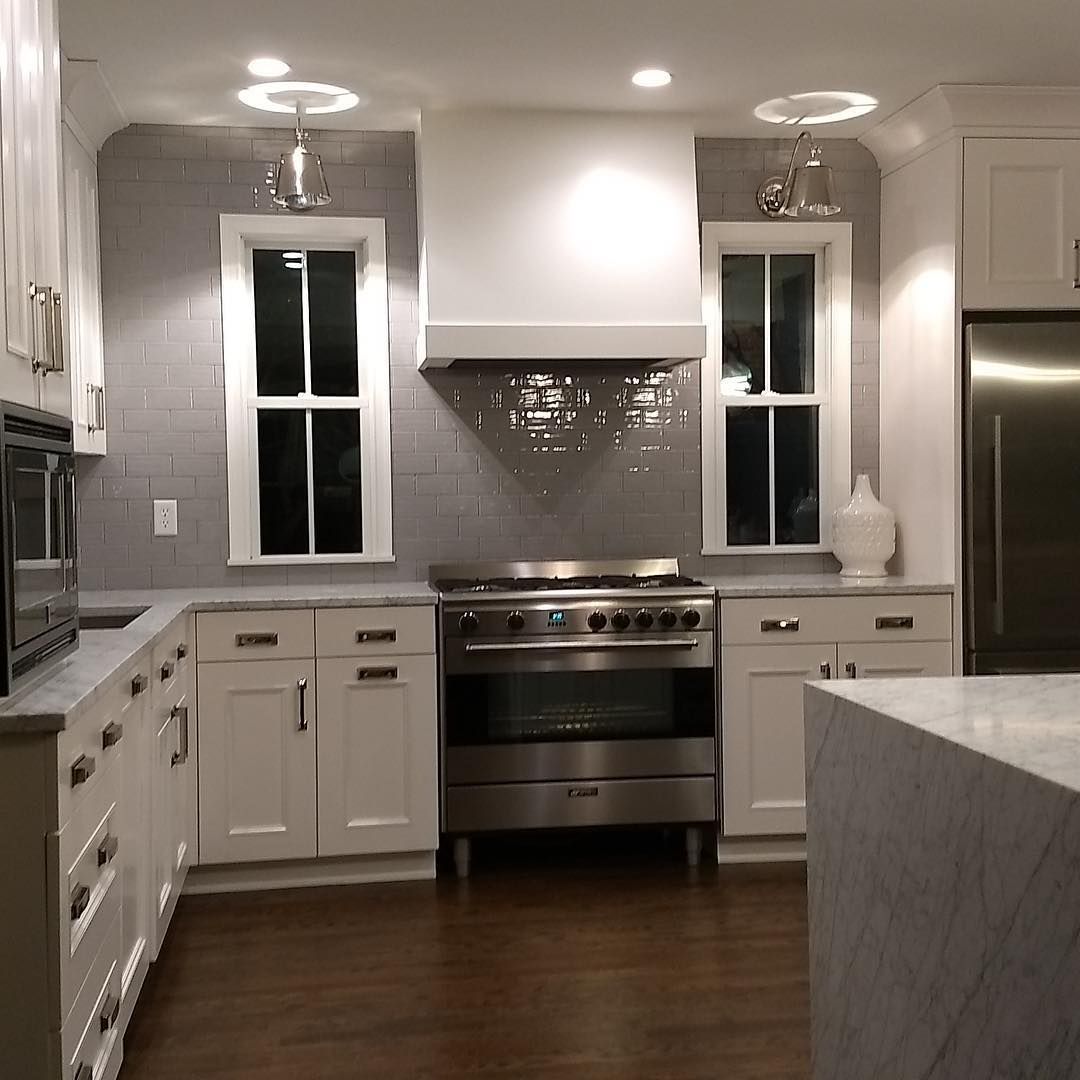 A kitchen with stainless steel appliances and white cabinets