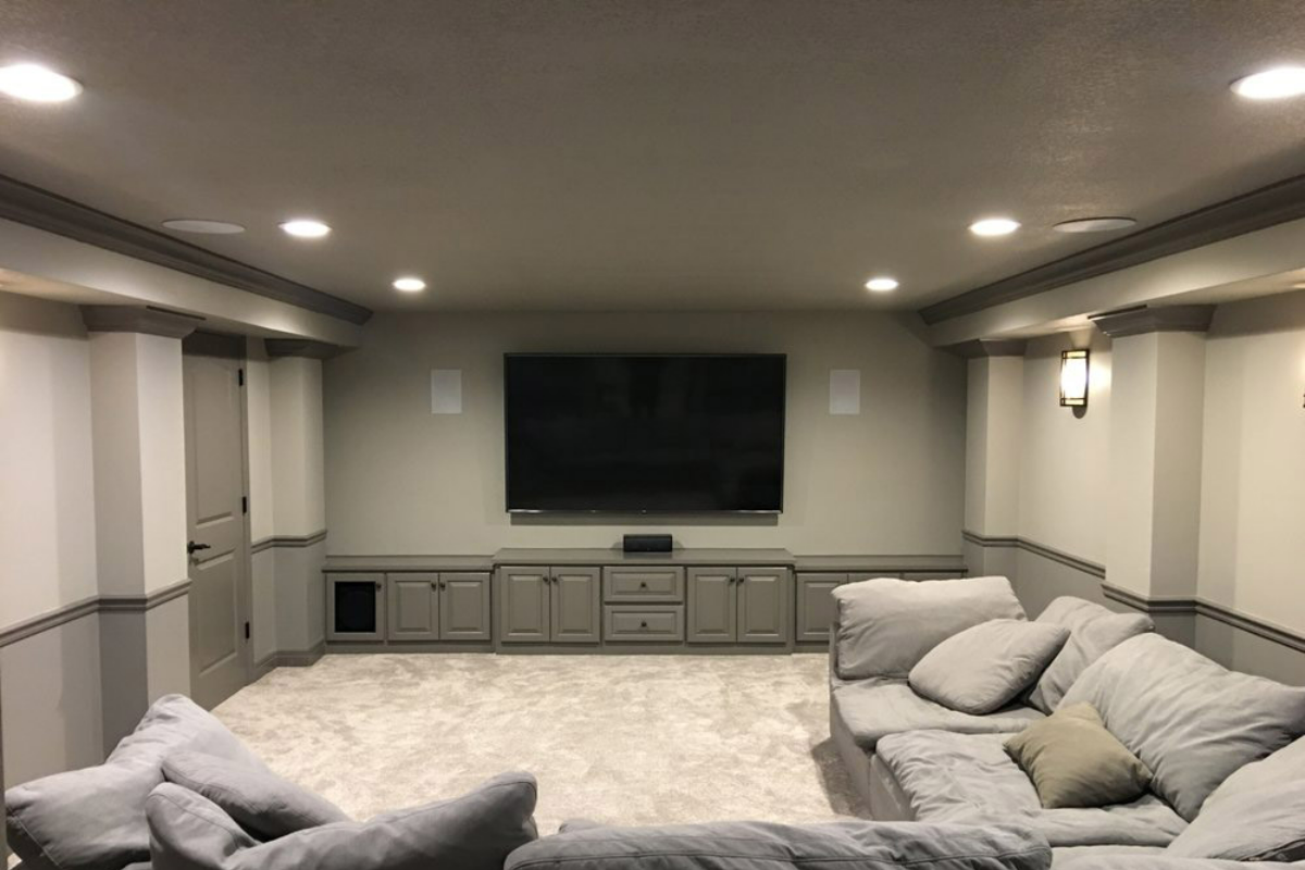 A living room with a couch and a flat screen tv on the wall.
