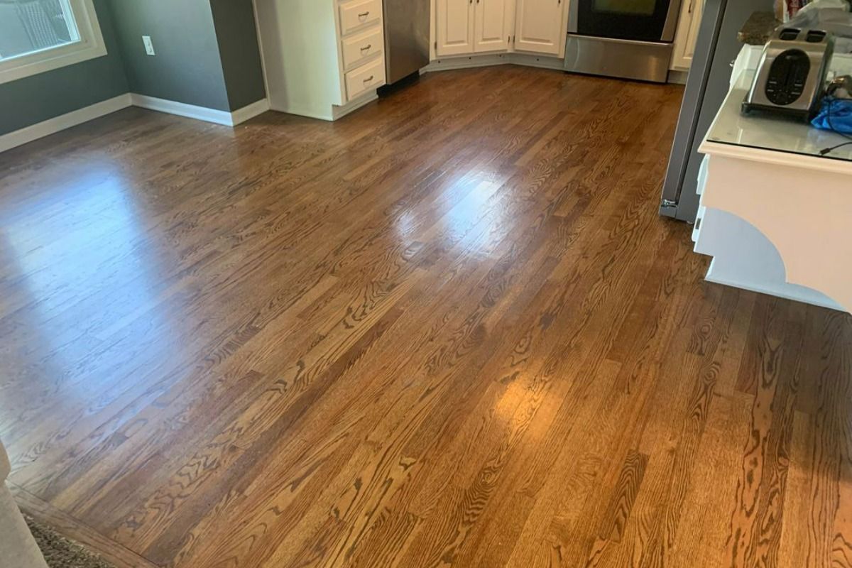 A kitchen with hardwood floors and stainless steel appliances.