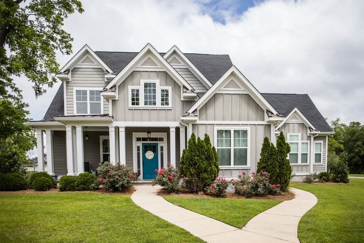 A large house with a blue door and a walkway leading to it.