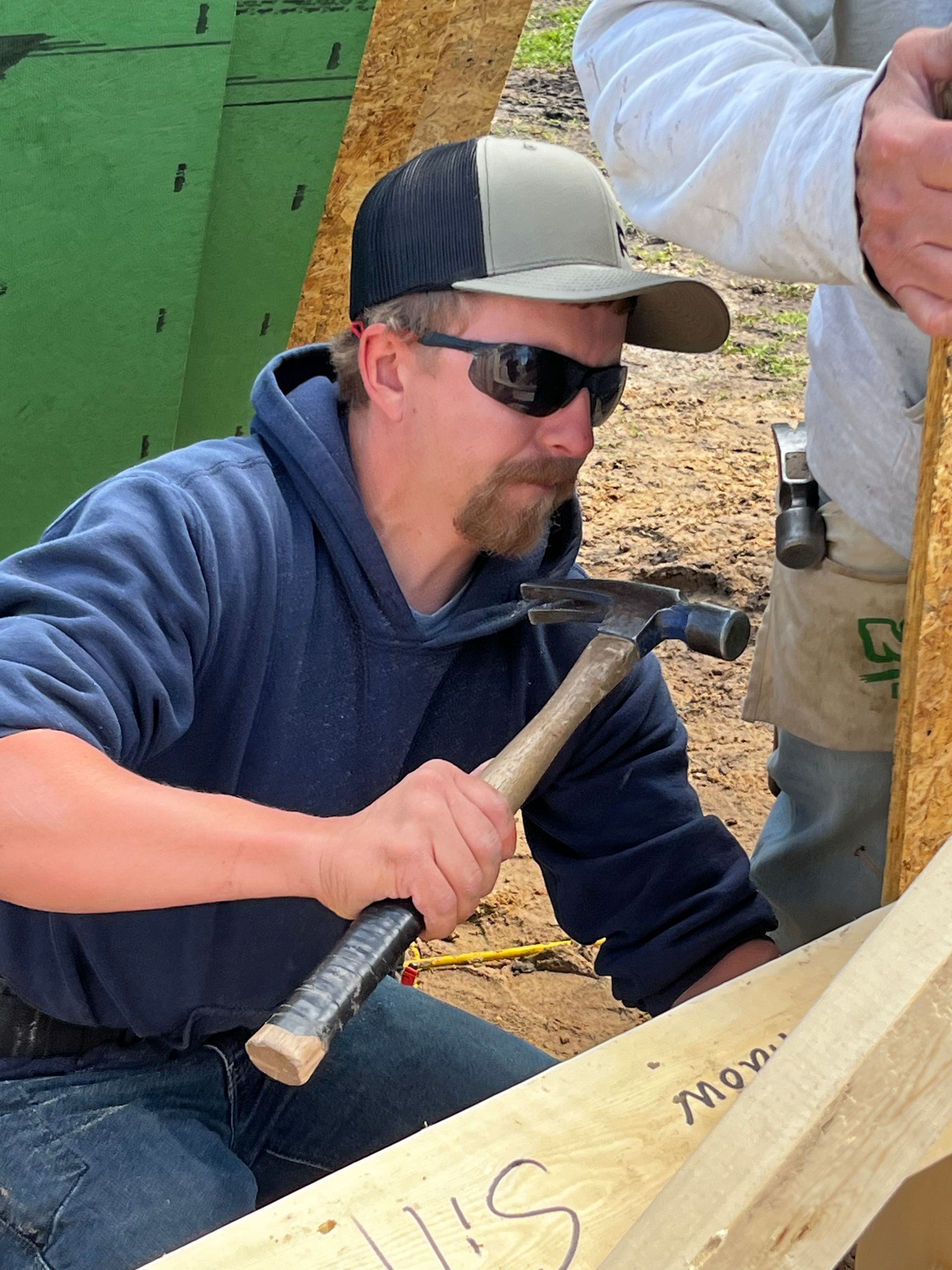 A man is driving nails into a piece of wood