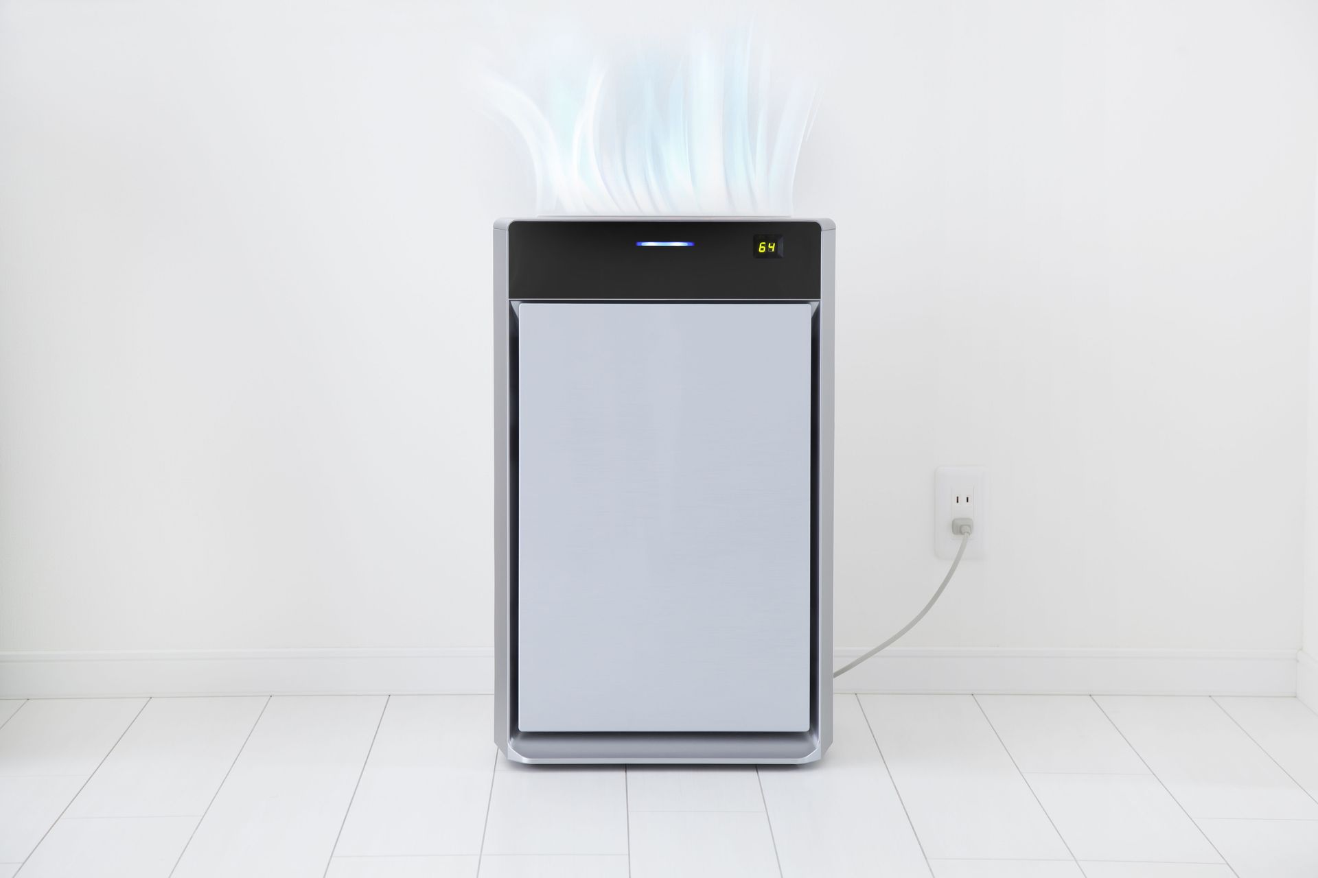 A silver air purifier stands against a white wall with blue, wispy airflow visual effects rising from its top.