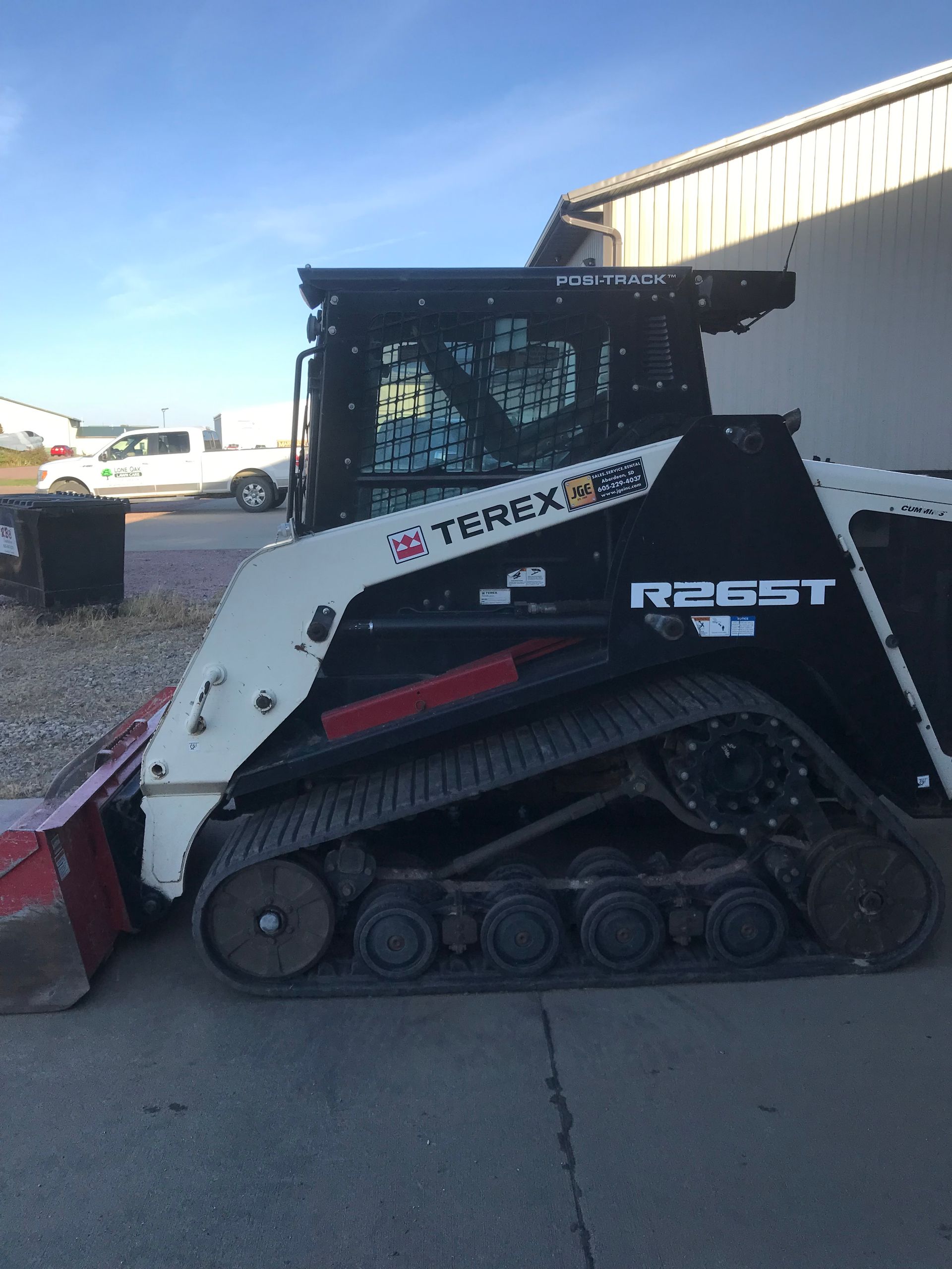 A terex snow plow is parked in front of a building.