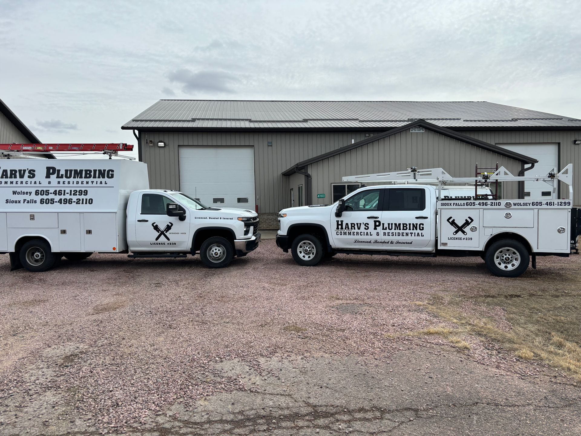 A white truck for harv's plumbing is parked in front of a building