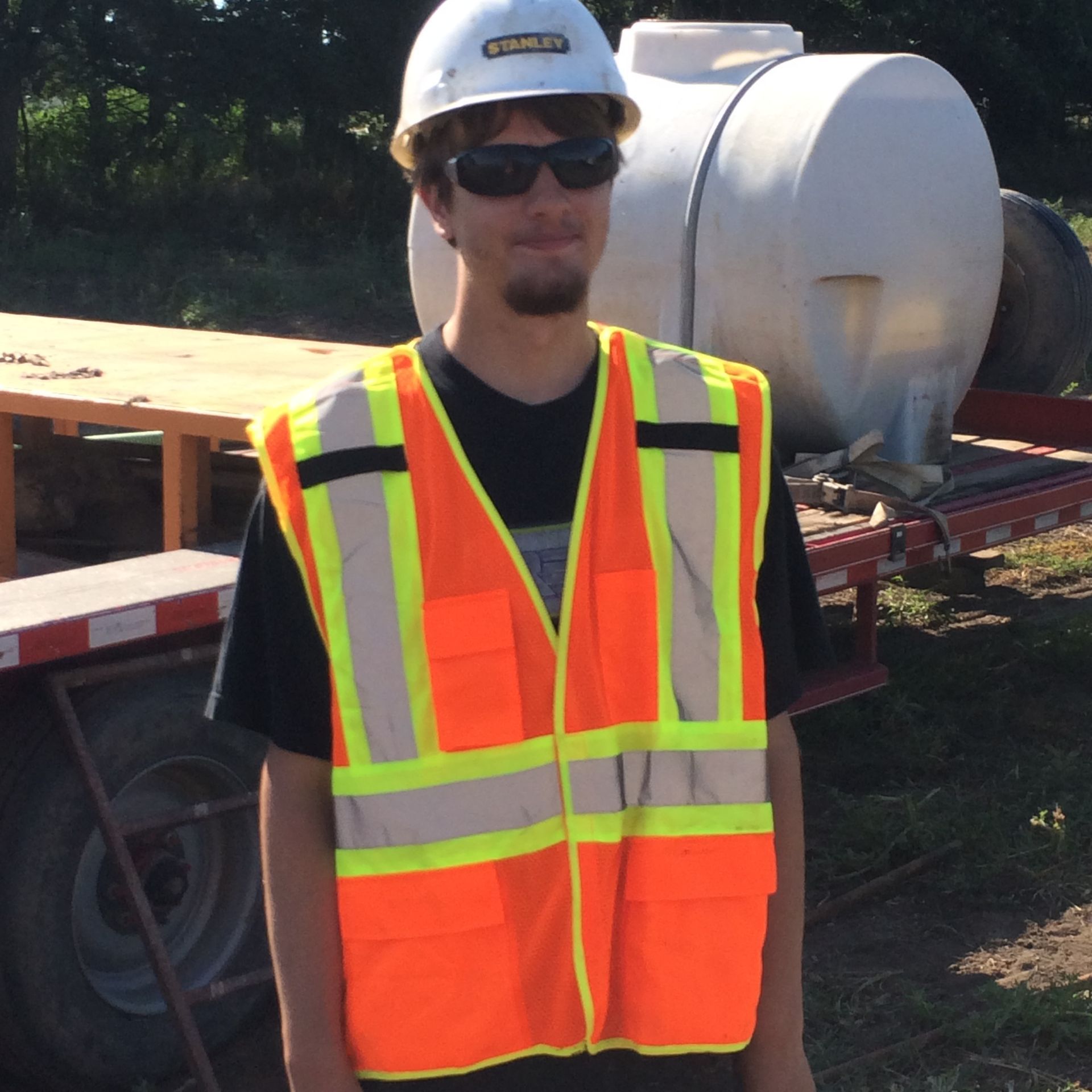 A man wearing a hard hat and an orange vest