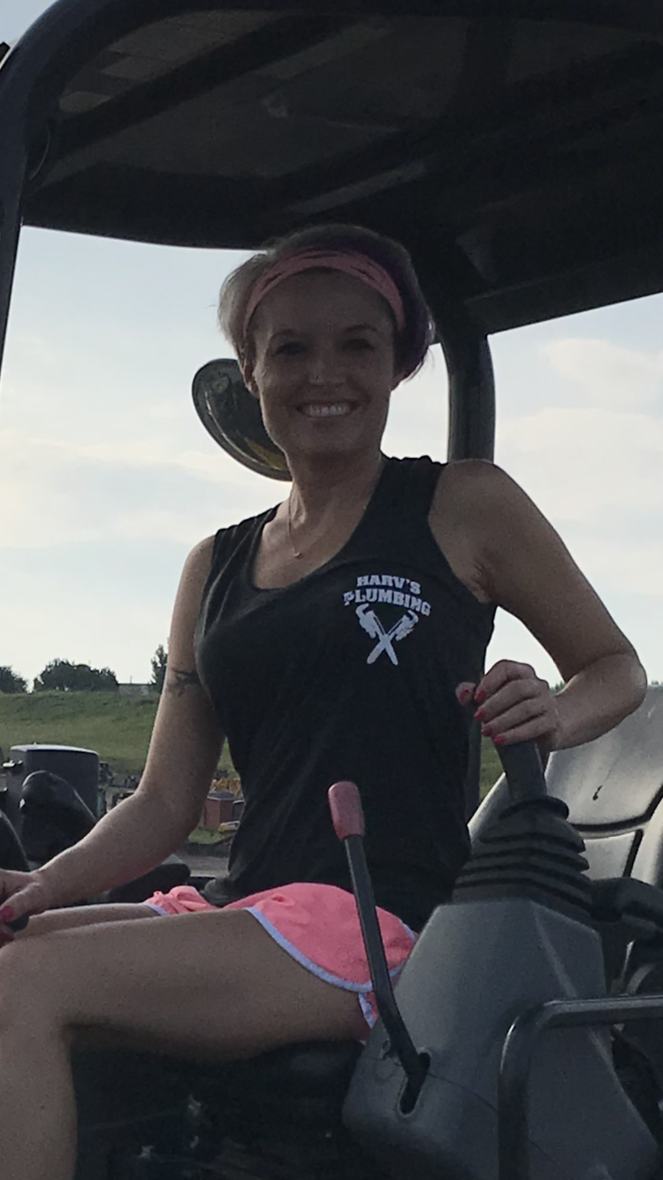 A woman is sitting in the driver's seat of a tractor