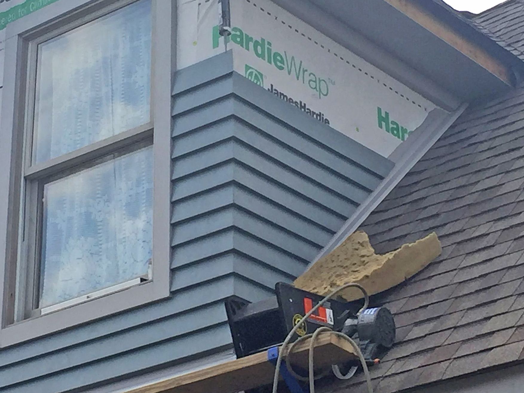 a window is being installed on the side of a house