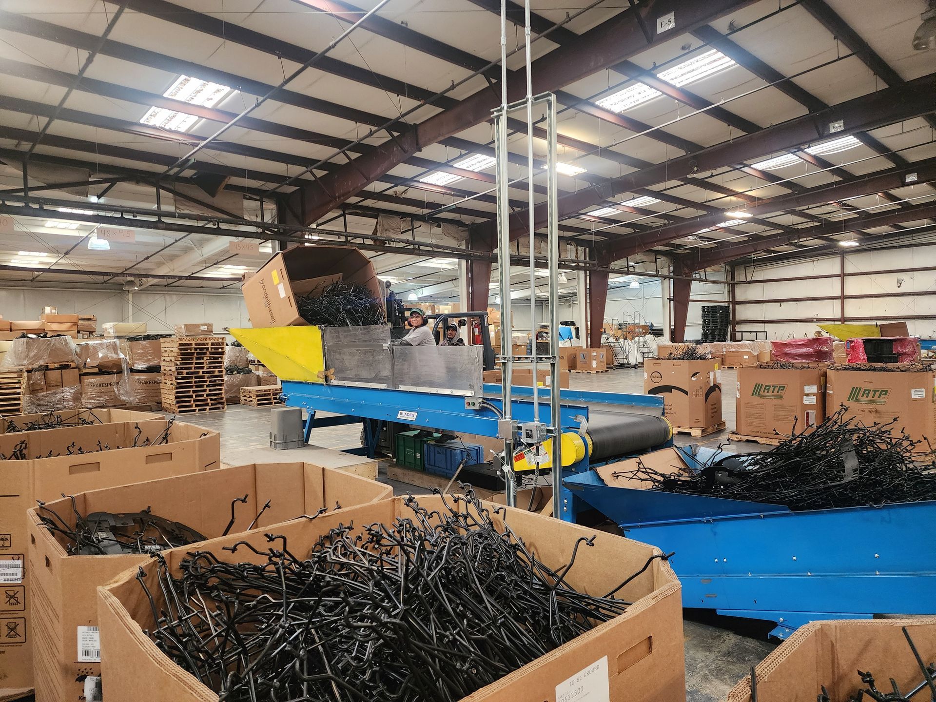A warehouse filled with lots of boxes and a conveyor belt.
