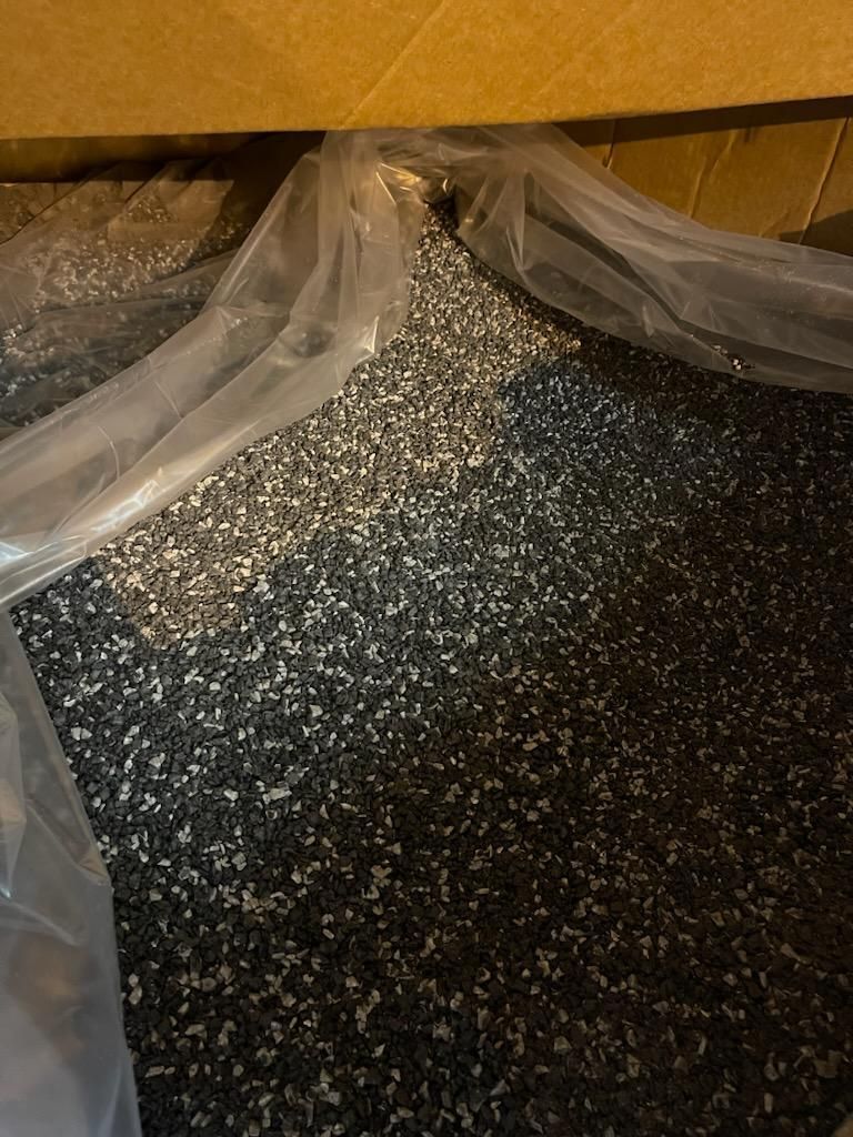 A bag of glitter is sitting on a table next to a box.