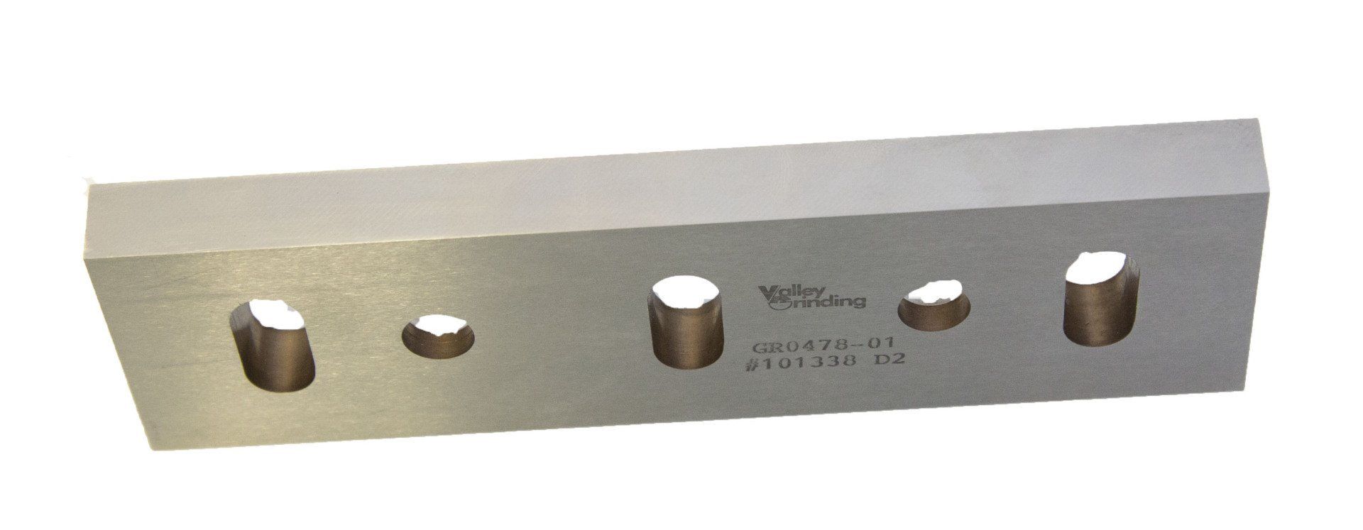 A piece of metal with holes in it on a white background.