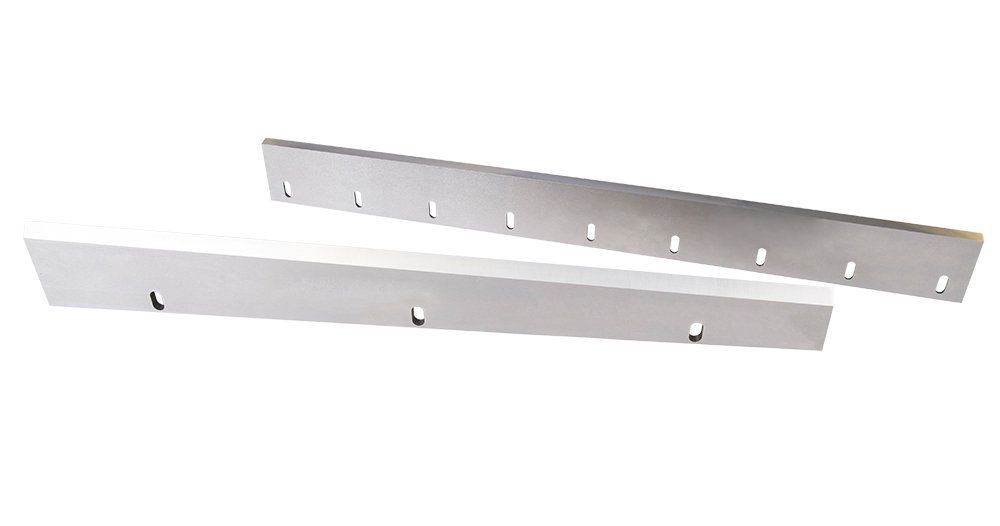 Two stainless steel knives are sitting next to each other on a white surface.