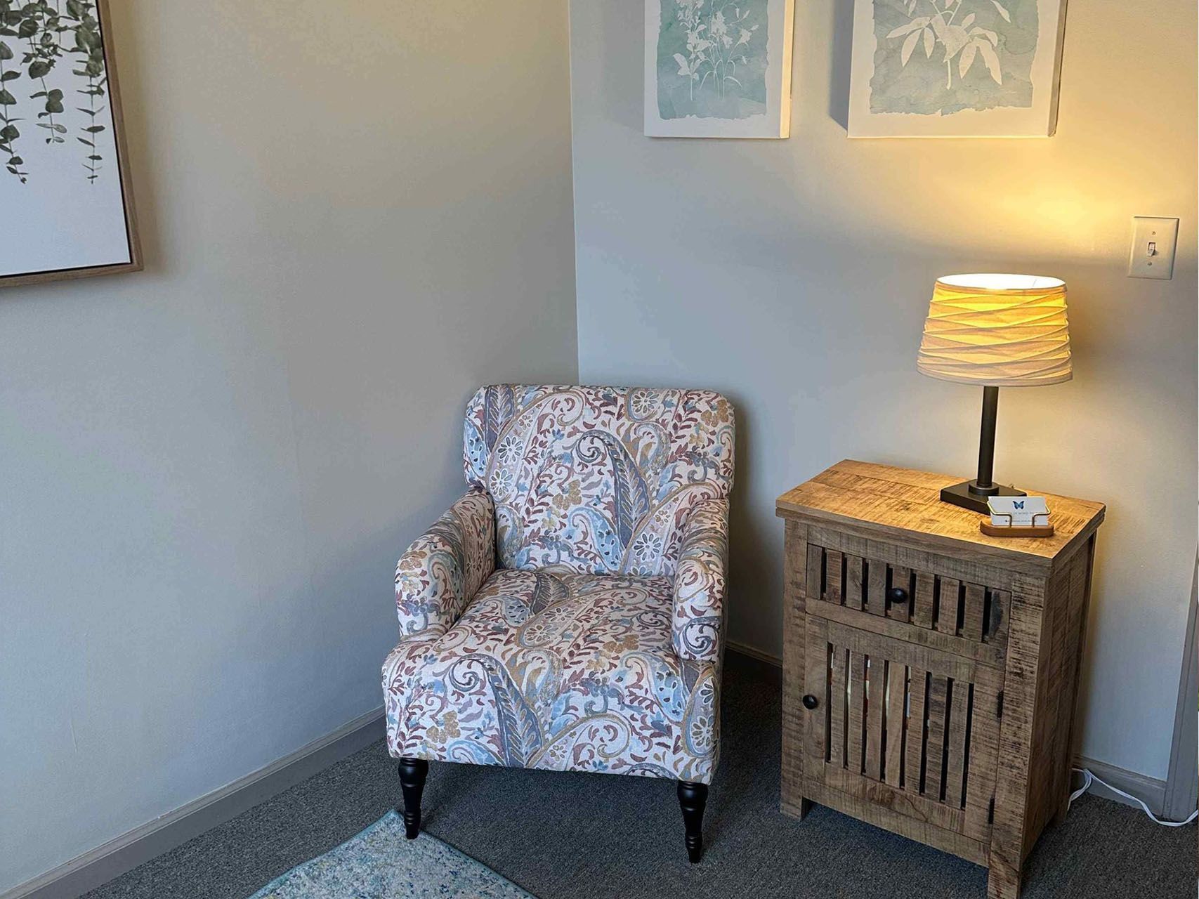 There is a chair and a lamp in the corner of the room.