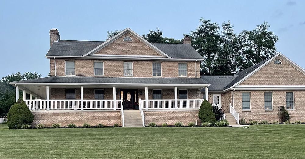 A large brick house with a porch and stairs