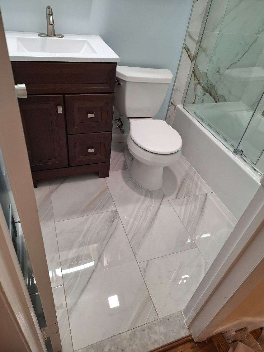 A bathroom with a toilet , sink , and bathtub.