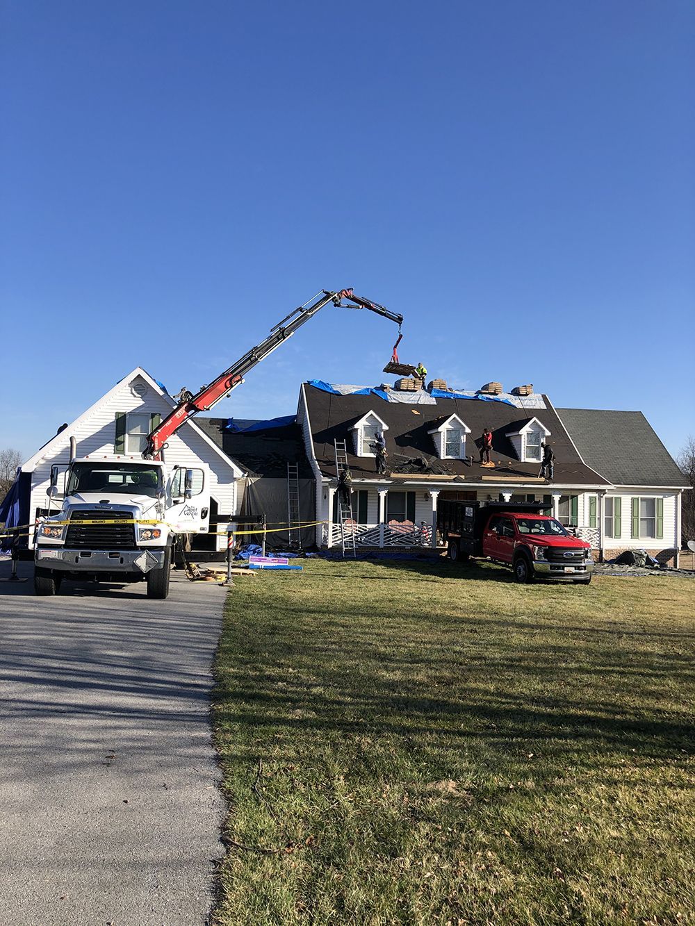 A crane is being used to install a roof on a house.