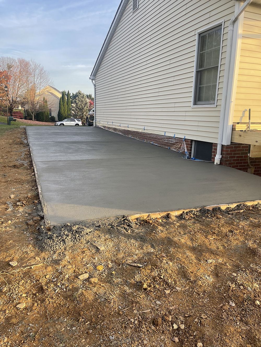 A concrete driveway is being built in front of a house.