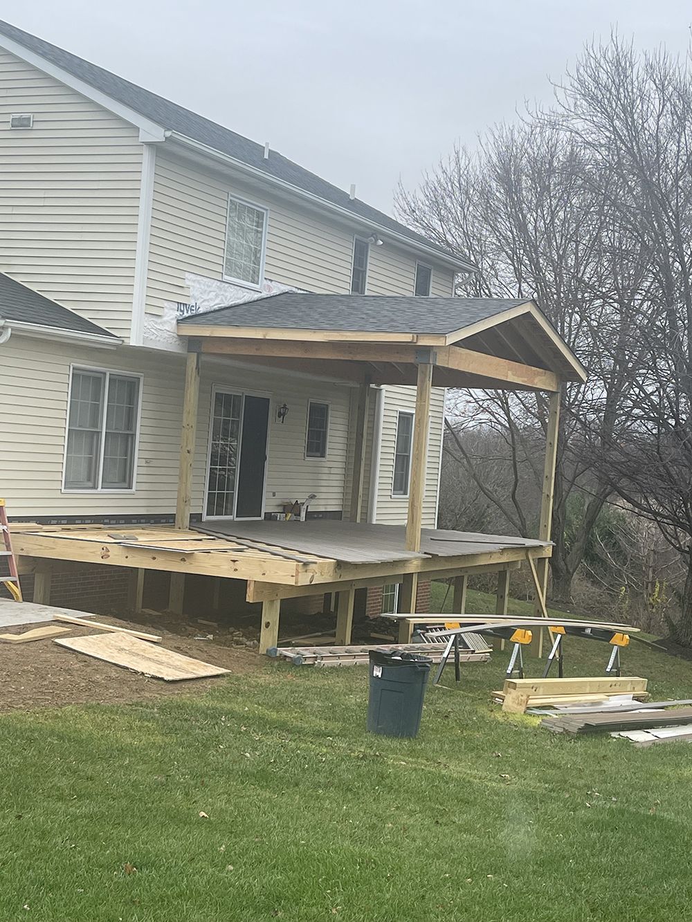 A wooden deck is being built in front of a house.