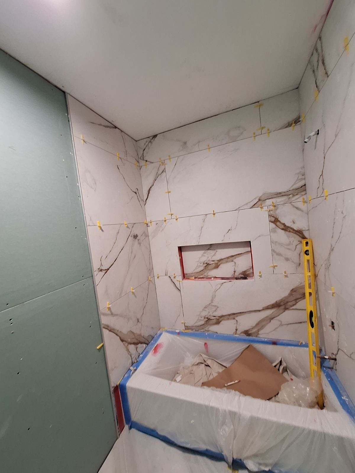 A bathroom under construction with a bathtub and a level.