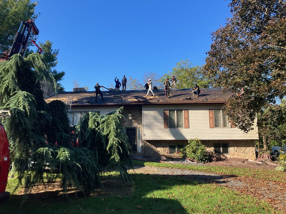 A group of people are working on the roof of a house.