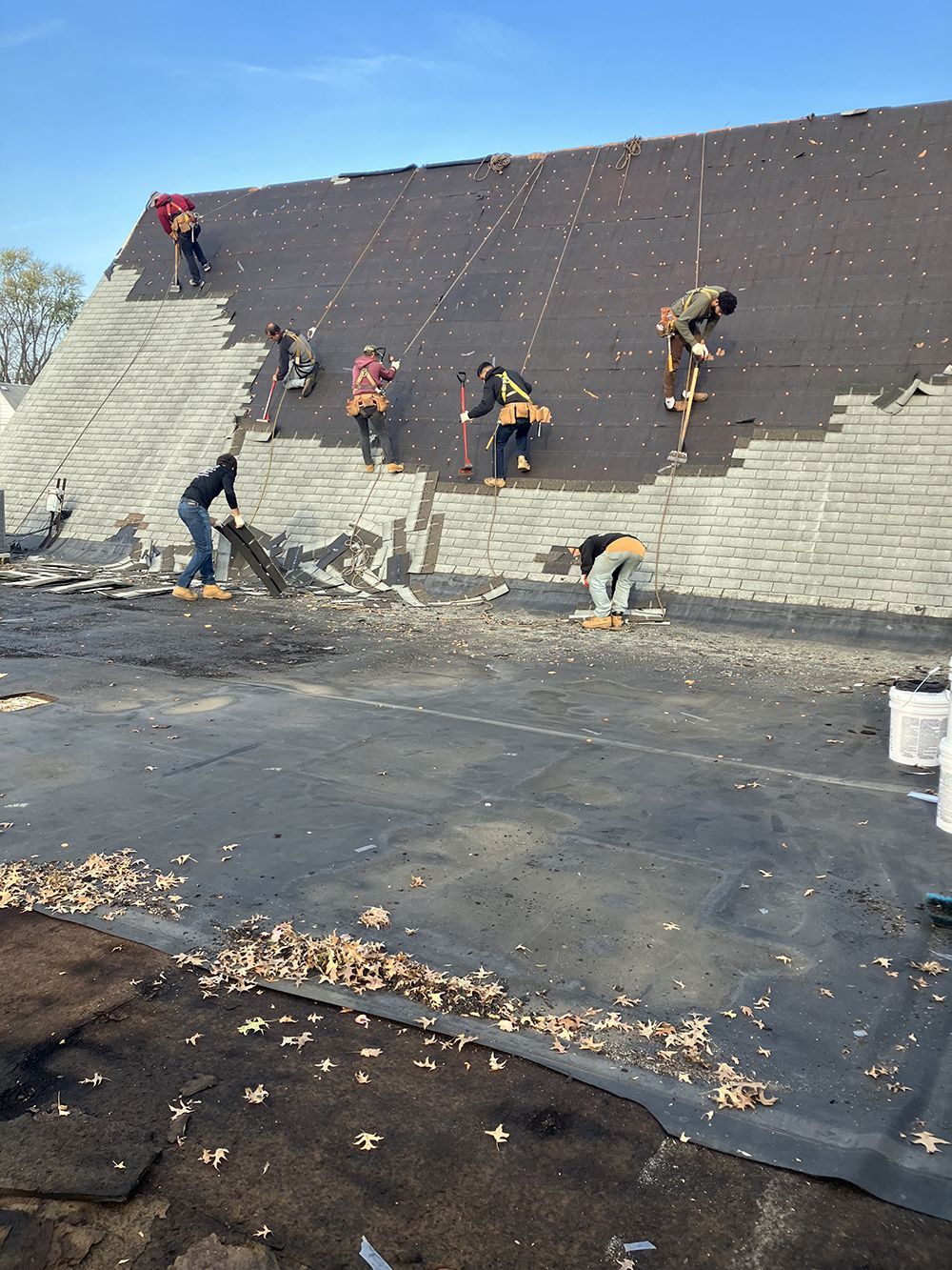 A group of people are working on the roof of a building.