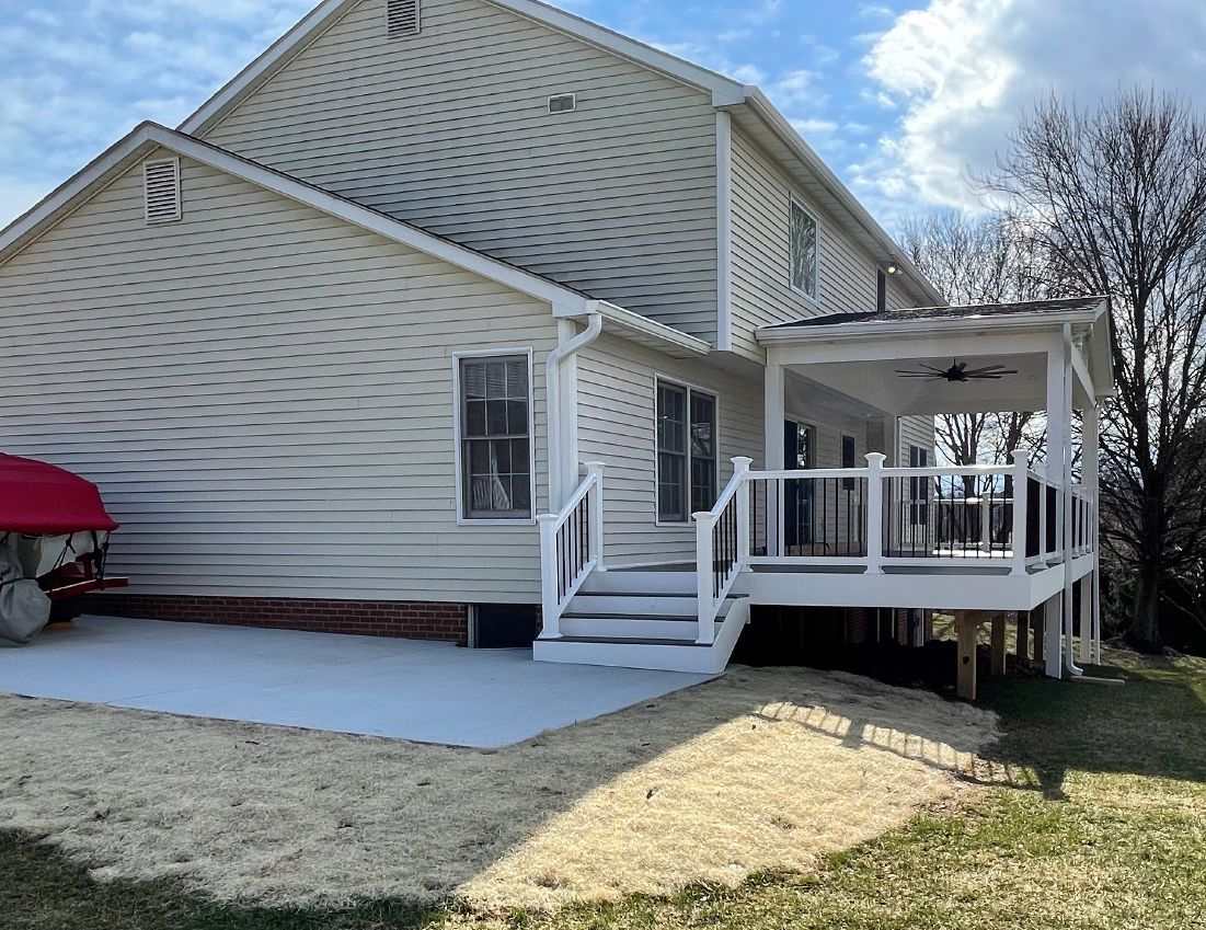 The back of a house with a large deck and stairs.