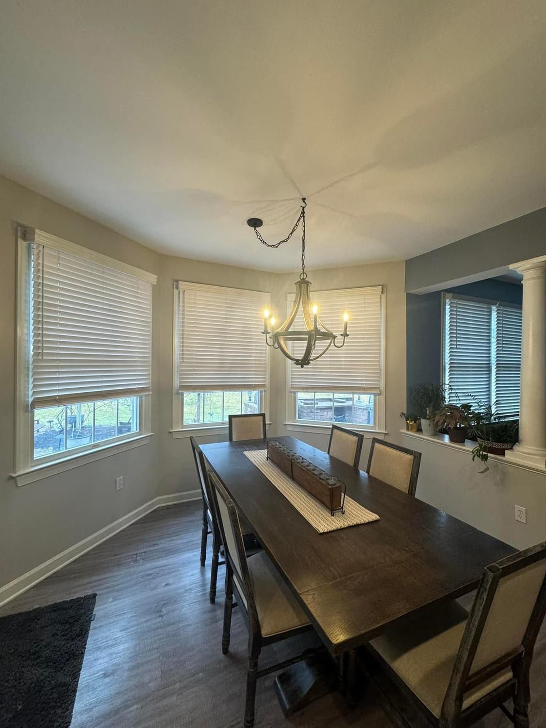 A dining room with a long table and chairs and a chandelier.