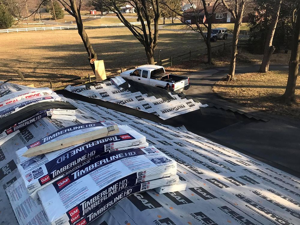 A truck is parked on top of a roof covered in shingles.