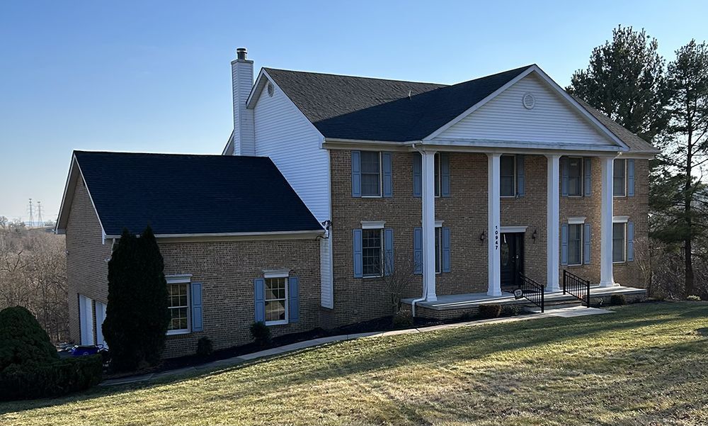A large brick house with columns and a blue roof