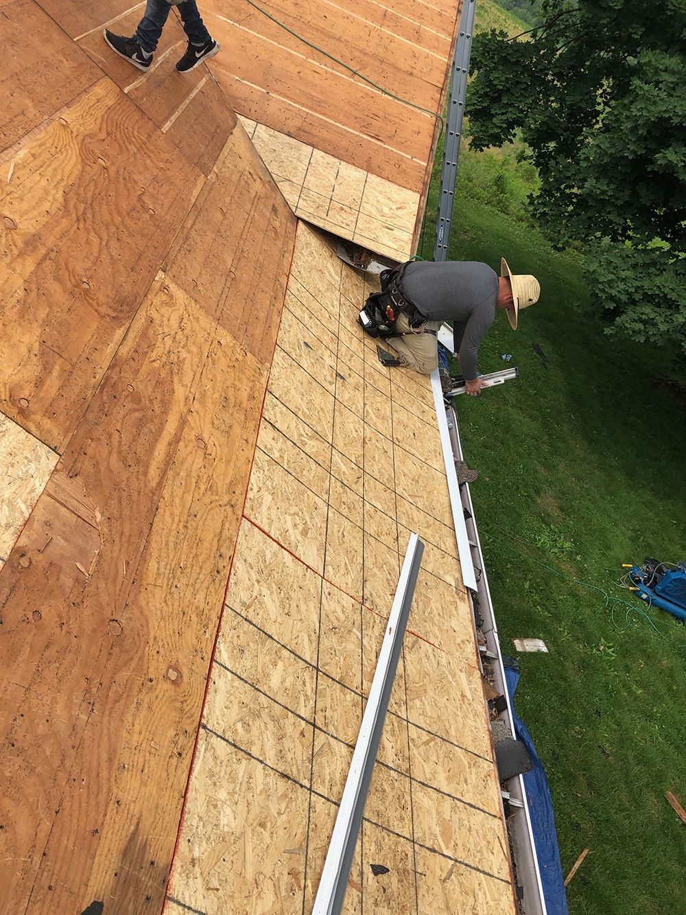 A man is working on the roof of a house.