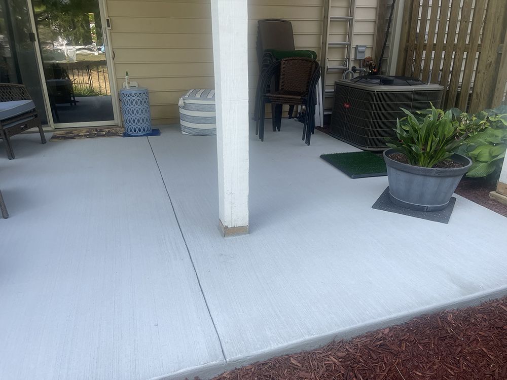 A patio with a ladder, chairs, and a potted plant.