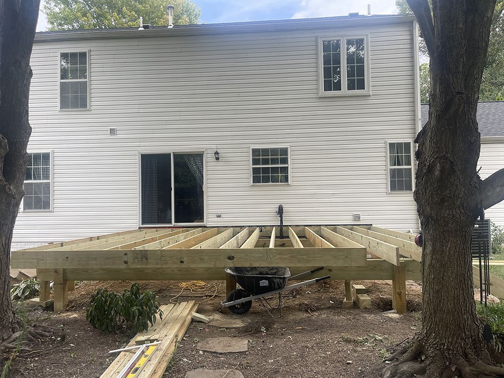 A wooden deck is being built in front of a house.