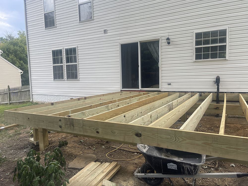 A wooden deck is being built in front of a house.