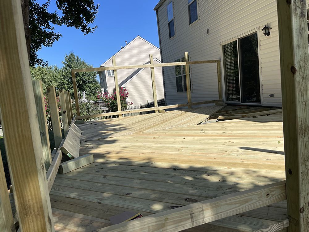 A wooden deck is being built in front of a house.