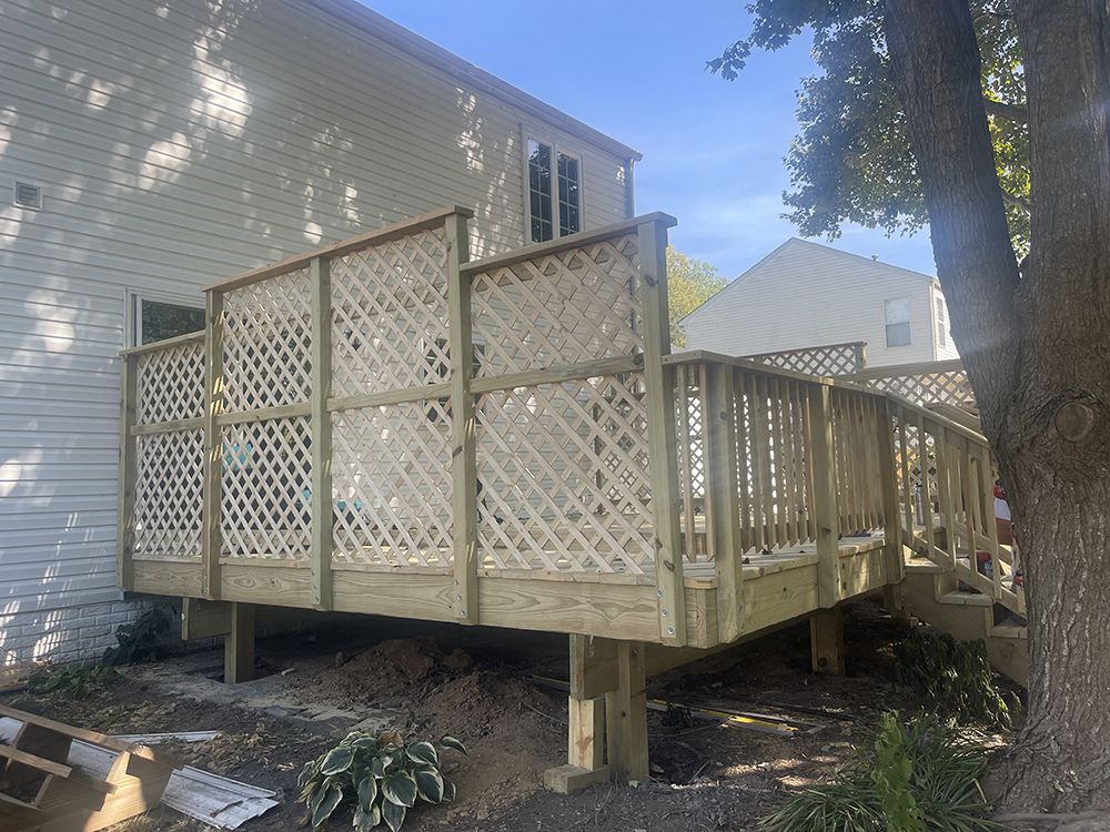 A wooden deck is being built in front of a house.