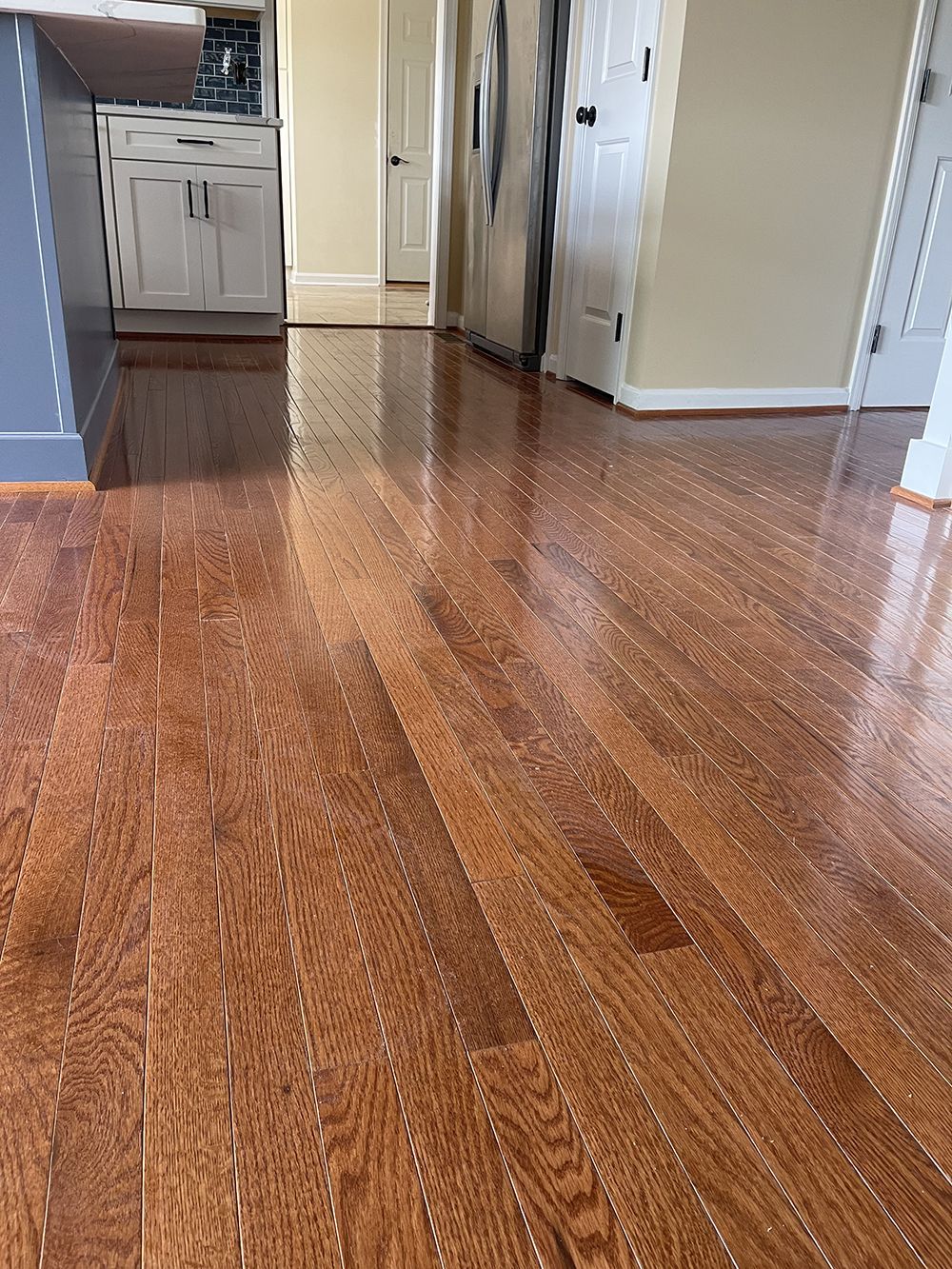 A kitchen with hardwood floors and a refrigerator.
