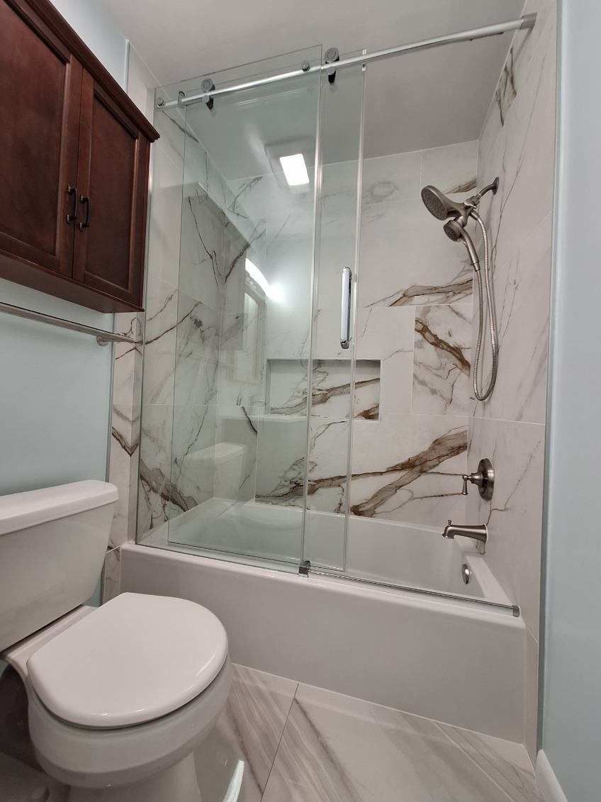 A bathroom with a toilet , bathtub and shower.