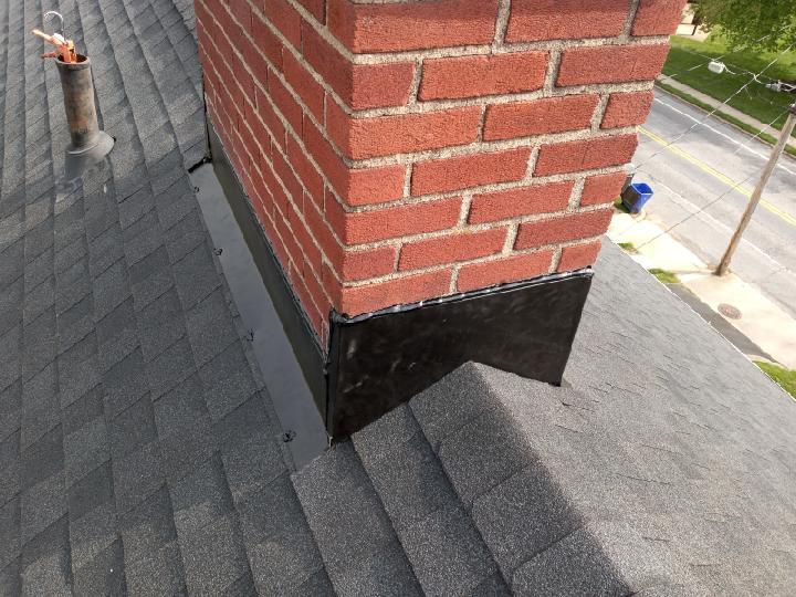 A brick chimney is sitting on top of a roof