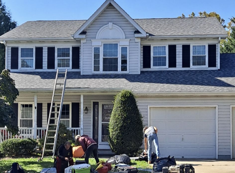 A group of men are working on the roof of a house