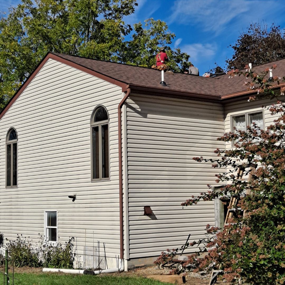 A white house with a brown roof and arched windows