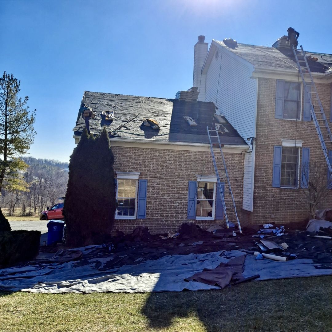 A brick house with a roof that is being repaired