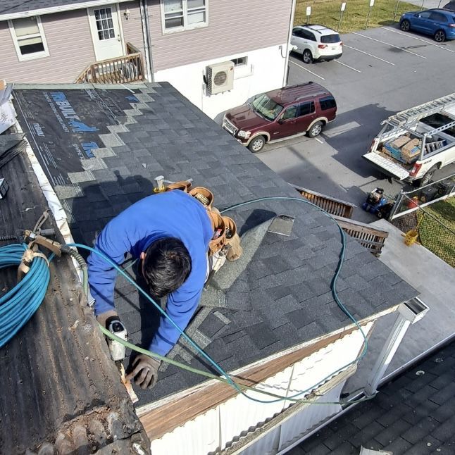 A man is working on the roof of a house