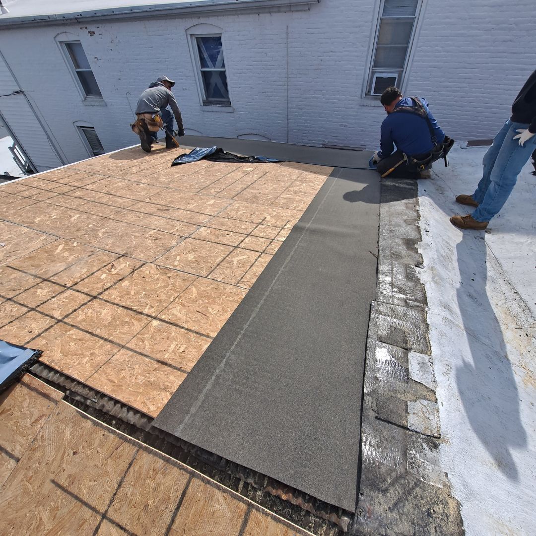 A group of men are working on the roof of a building
