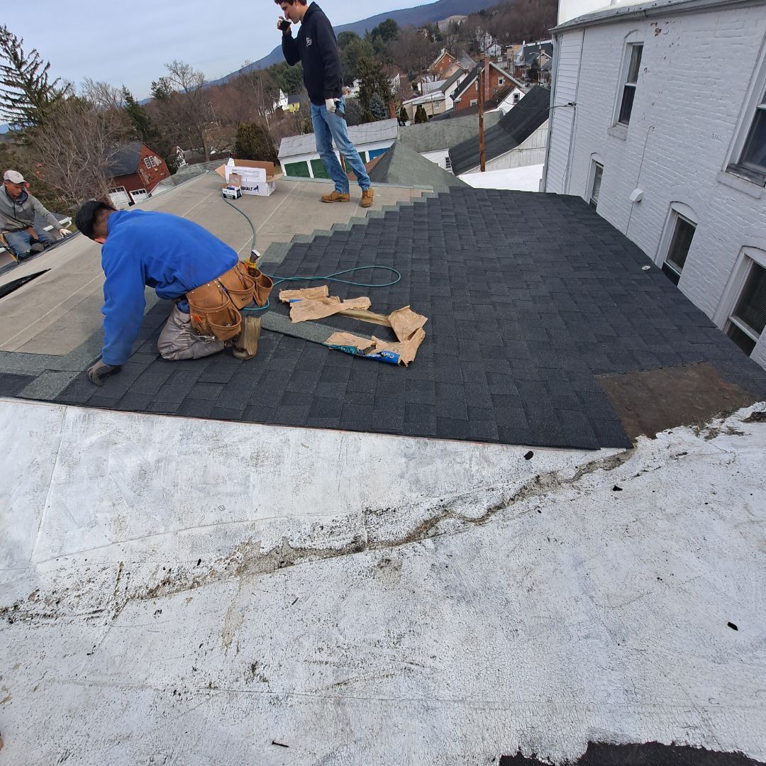 A group of people are working on a roof.