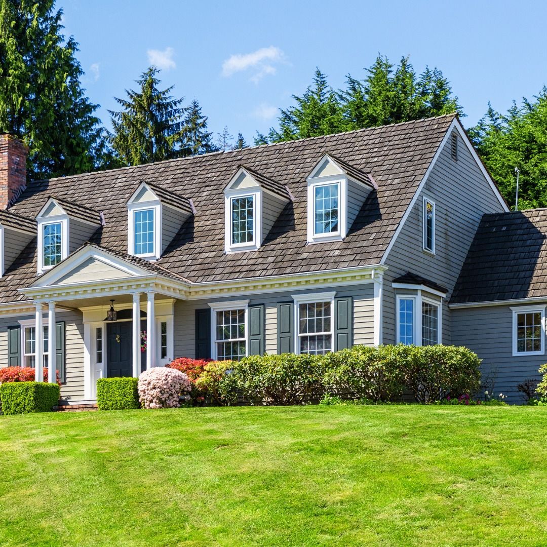 A large house with a lush green lawn in front of it.