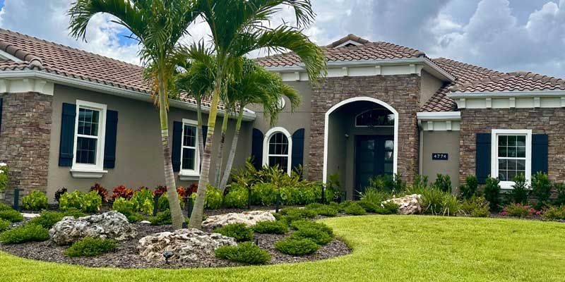 A large house with a palm tree in front of it.